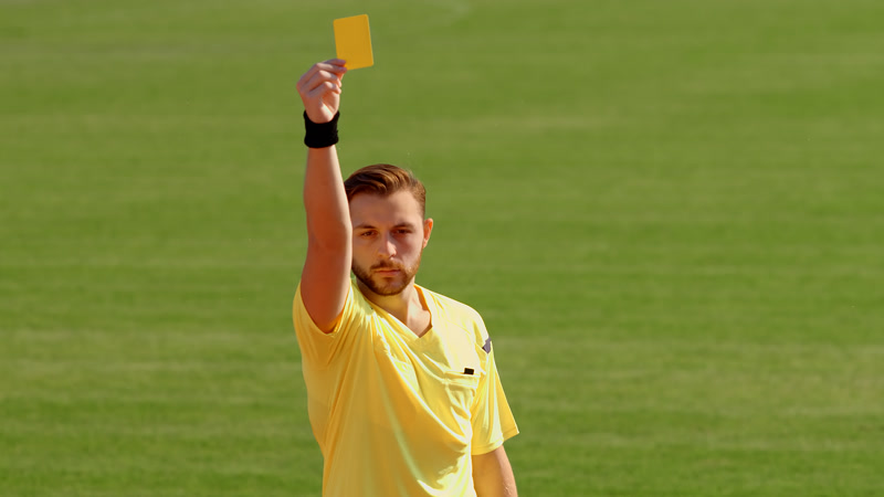 Soccer referee showing both yellow and red cards