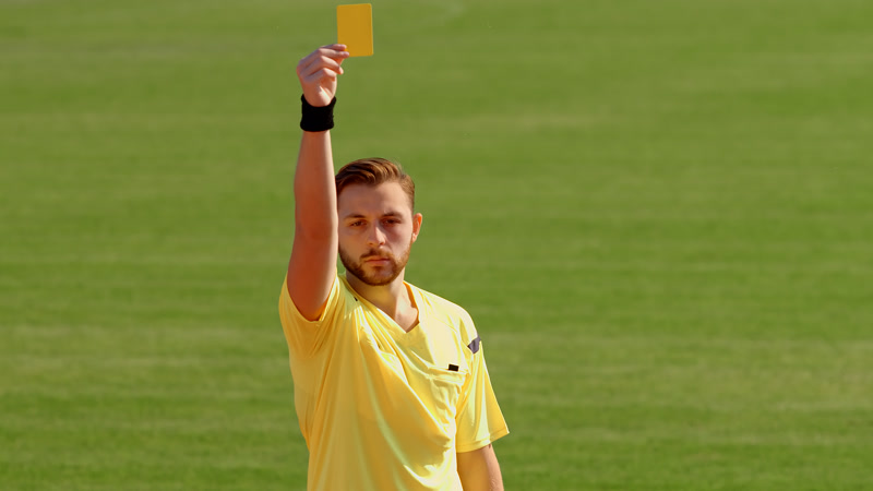 Soccer referee showing the yellow card